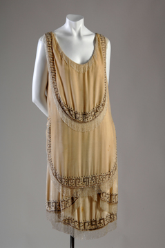 mannequin in a beige tiered flapper dress with Greek decorative border